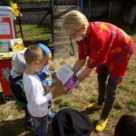 pracownik Filii Bibliotecznej w Wyszanowie pokazuje przedszkolakom książki