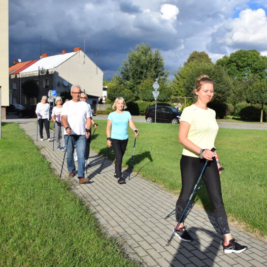 fizjoterapeutka i uczestnicy podczas marszu nordic walking