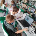 dzieci pracują na komputerach i z długopisami 3D