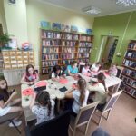 Biblioteka zajęcia edukacyjno-czytelnicze dzieci siedzą przy stole, malują