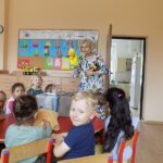 Spotkanie w przedszkolu dzieci i bibliotekarka przy stole