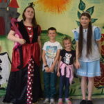 dzieci stoją z aktorami ze spektaklu "Alicja w Krainie Czarów"