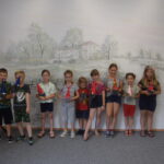 grupka dzieci stoi z własnoręcznie wykonanymi krasnalami ze skarpet