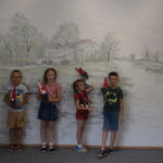 4 dzieci stoi z własnoręcznie wykonanymi krasnalami ze skarpet