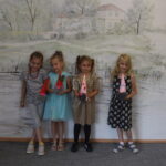 4 dzieci stoi z własnoręcznie wykonanymi krasnalami ze skarpet