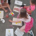 czytanie na spontanie, czytanie z reksiem, grupa dzieci maluje worki lniane farbami