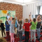 teatrzyk, dzieci ćwiczą na stojąco wraz z aktorką