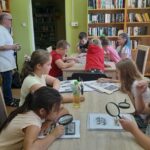 spotkanie z filatelistą, dzieci przy stołach oglądają znaczki