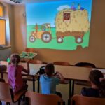dzieci oglądają obraz wyświetlony na ścianie