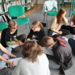 Projekt młodzieżowy, grupa młodzieży siedzi na podłodze