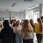 Projekt młodzieżowy, grupa młodzieży rozmawia ze sobą, stoją na środku sali