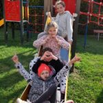 czworo dzieci pozuje do zdjęcia na zjeżdżalni na placu zabaw