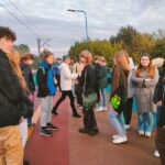 Grupa młodzieży stoi na peronie dworca pkp