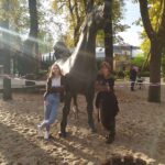 dwie dziewczyny stoją obok rzeźby konia
