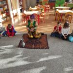 bibliotekarka przebrana za Alladyna czyta dzieciom bajkę, siedzą na dywanie