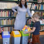 chłopiec segreguje śmieci do kolorowych koszy, bibliotekarka opowiada