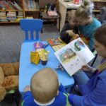 mamy i dzieci czytają przy stole