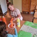 dwoje dzieci wspólnie maluje obrazek przy stole