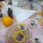 stół, świeczki sojowe w połówkach pomarańczy, woski sojowe