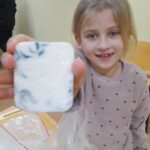 dziewczynka pokazuje zrobione mydełko
