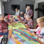 Seniorki malują siedząc przy stole