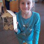 dziewczynka prezentuje złożony domek dla owadów