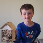 chłopiec prezentuje domek dla owadów