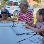 Festyn w Cieszęcinie z okazji Dnia Dziecka, dzieci malują z bibliotekarką