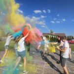 Projekt młodzieżowy Ziołowe love - kilka młodych osób sypią się proszkami holi, w powietrzu mnóstwo barw