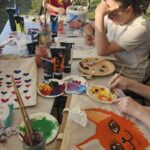 Projekt młodzieżowy Ziołowe love - widok na stół z malowanymi torbami i malujących