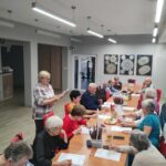 grupa seniorów rozwiązuje zadania na pamięć i koncentrację