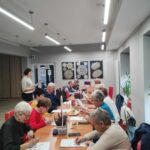 grupa seniorów rozwiązuje zadania na pamięć i koncentrację