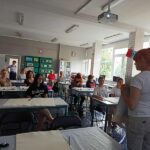 w sali grupa osób siedzi przy stolikach