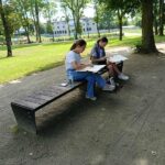 park, dwie dziewczynki siedzą na ławce, malują