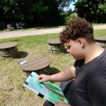 park, chłopak siedzi i maluje