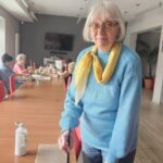 Seniorka w niebieskim swetrze, obok na stole ulepiony jeszcze biały słoń