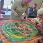 seniorki malują wspólny obraz w zieleniach