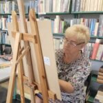warsztaty malarskie, kobieta pracuje przy sztalugach