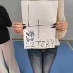 dziewczyna trzyma w rękach kartkę z napisem 4