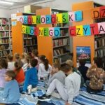 dzieci siedzą na kocyku w tle napis Ogólnopolski Dzień Głośnego Czytania
