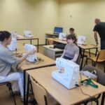 warsztaty szycia, uczestnicy przy maszynach