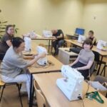warsztaty szycia, uczestnicy przy maszynach