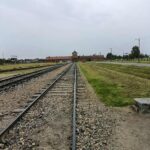 Birkenau, rampa z torami kolejowymi, w tle brama