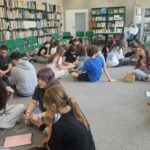 Grupa młodzieży siedząca na dywanie
