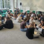 Grupa młodzieży siedząca na dywanie