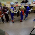 dzieci stoją gęsiego, w dłoniach trzymają uszyte kółka