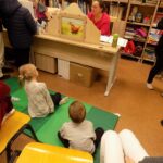 dzieci patrzą na teatrzyk kamishibai