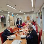 grupa osób siedzi na krzesłach i wykonuje zadania na pamięć i koncentrację