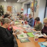 warsztaty artystyczne, uczestnicy pracują przy długim stole