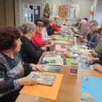 warsztaty artystyczne, uczestnicy pracują przy długim stole